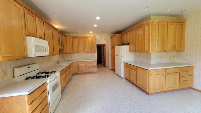 kitchen with sink, backsplash, and white appliances