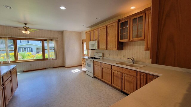 kitchen featuring ceiling fan, sink, and white appliances