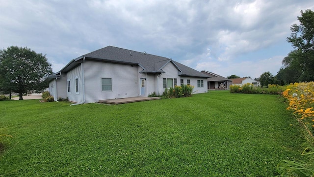 rear view of house with a patio and a lawn