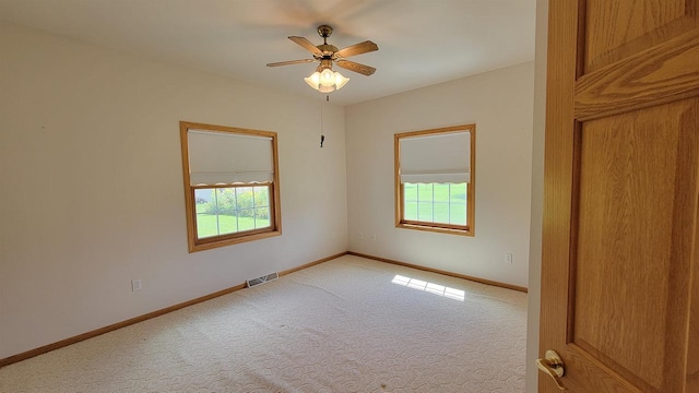 unfurnished room featuring ceiling fan, plenty of natural light, and light carpet