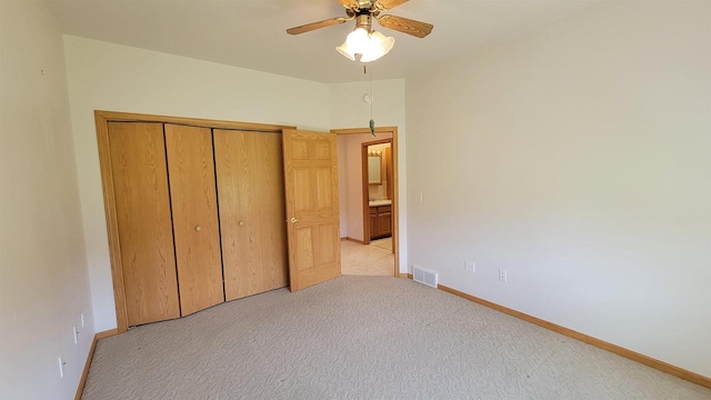 unfurnished bedroom featuring a closet, ceiling fan, and light colored carpet