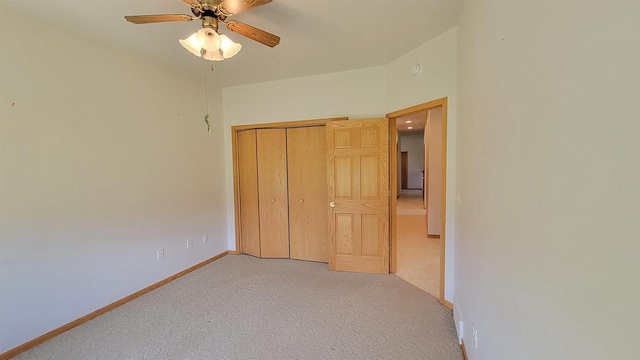 unfurnished bedroom featuring ceiling fan, light carpet, and a closet