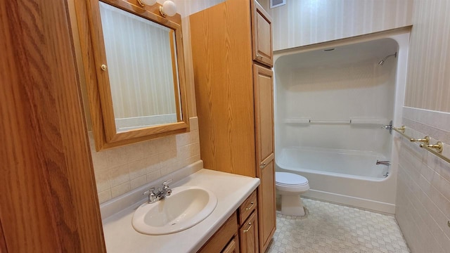 full bathroom featuring toilet, tasteful backsplash, vanity, tile walls, and tile patterned floors