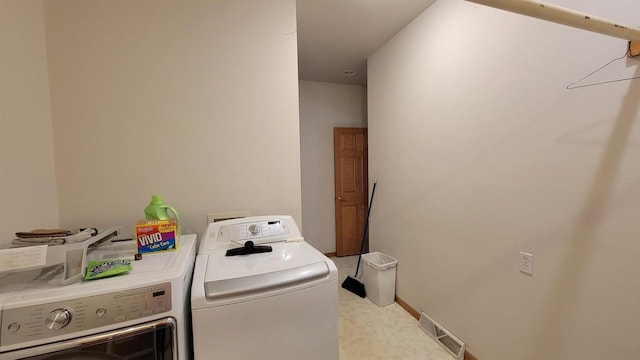 washroom with light tile patterned floors and washer and dryer