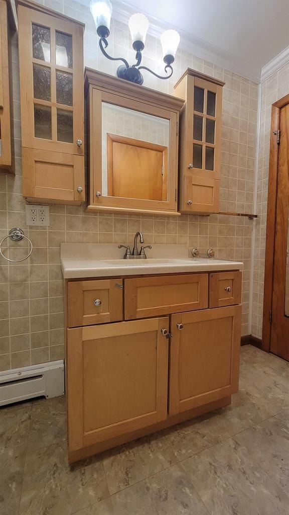 bathroom featuring decorative backsplash, a baseboard radiator, crown molding, vanity, and tile walls