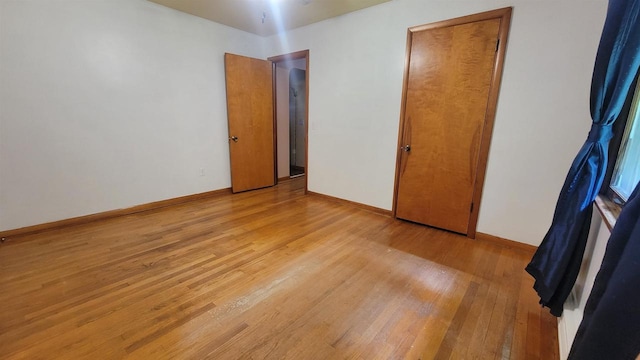 empty room with light wood finished floors and baseboards