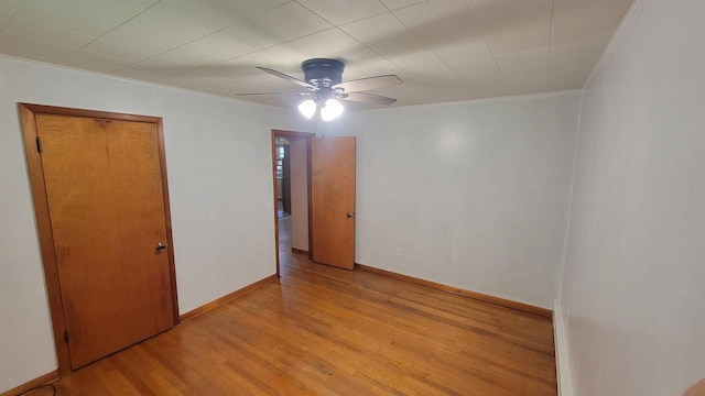 unfurnished room featuring light wood-style floors, baseboards, and a ceiling fan