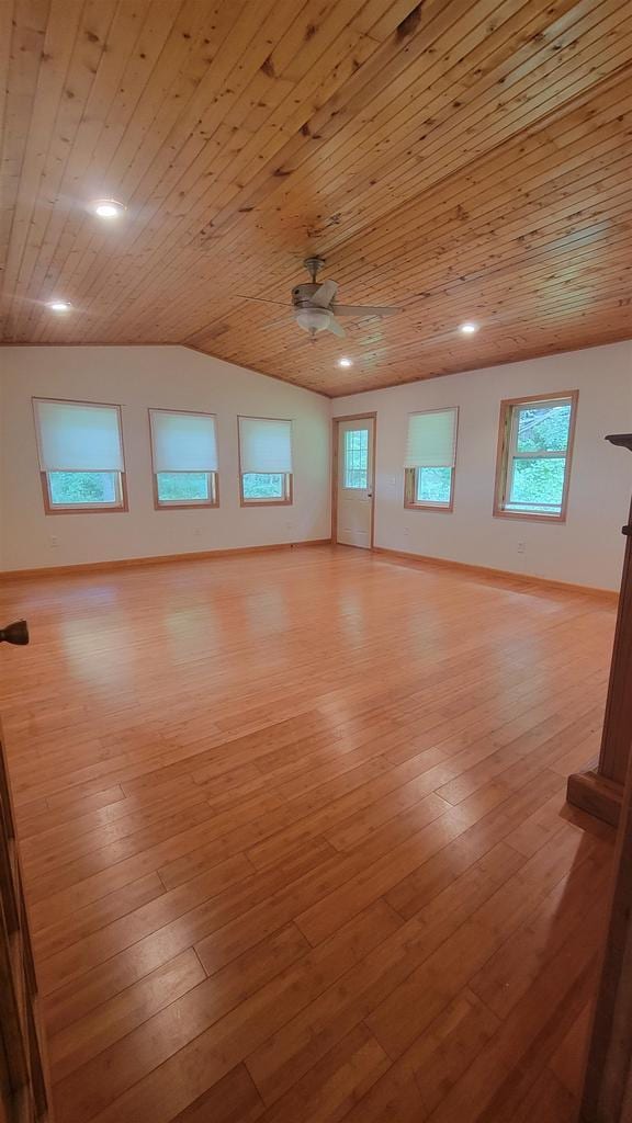 unfurnished room with light wood-style floors, vaulted ceiling, and baseboards