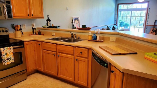 kitchen featuring light tile patterned flooring, sink, stainless steel appliances, and kitchen peninsula