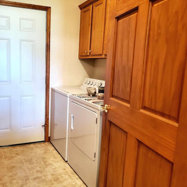 laundry room featuring washer and dryer, cabinets, and light tile patterned floors