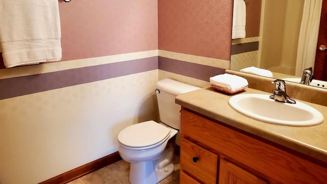 bathroom with toilet, tile patterned floors, and vanity