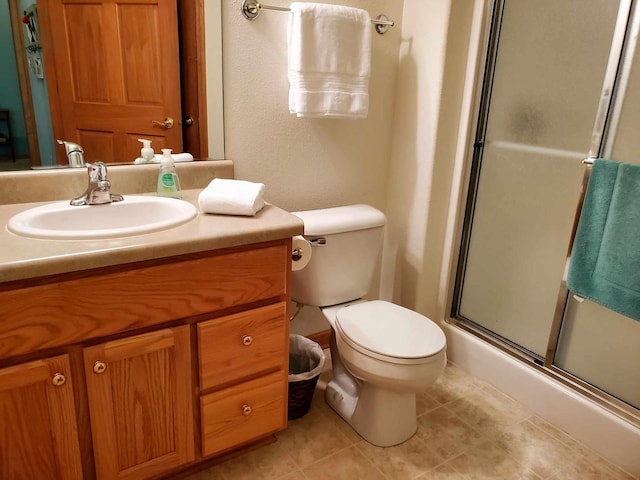 bathroom featuring tile patterned floors, a shower with shower door, vanity, and toilet