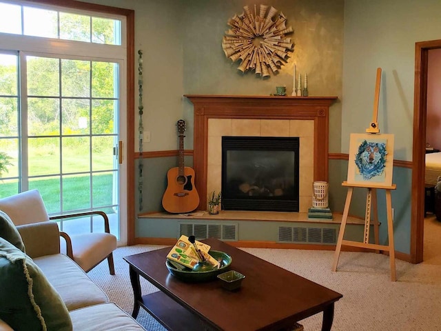 carpeted living room with a tiled fireplace