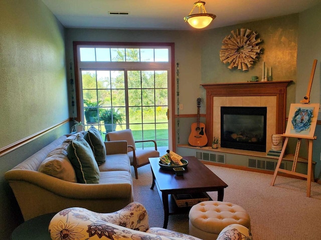 carpeted living room with a tile fireplace