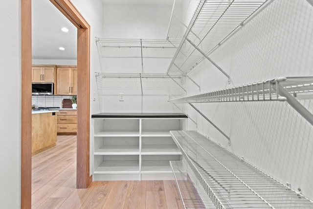 spacious closet featuring light wood-style flooring