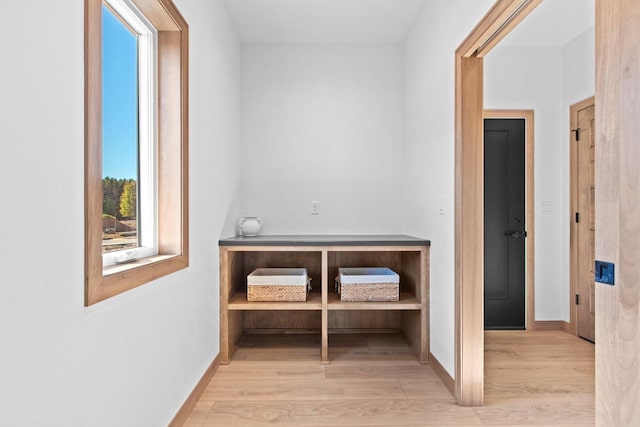 hall with light wood-style floors and baseboards