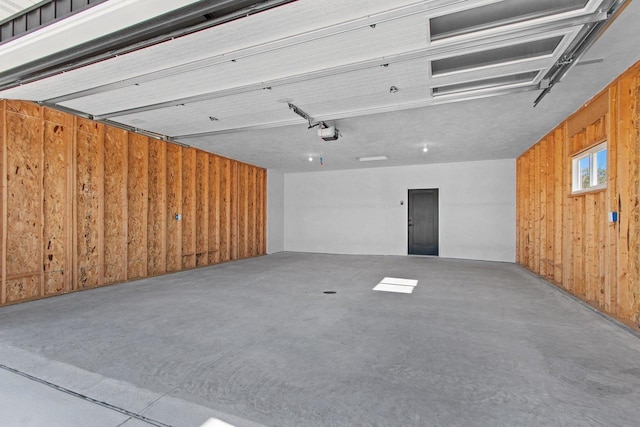 garage featuring wooden walls and a garage door opener