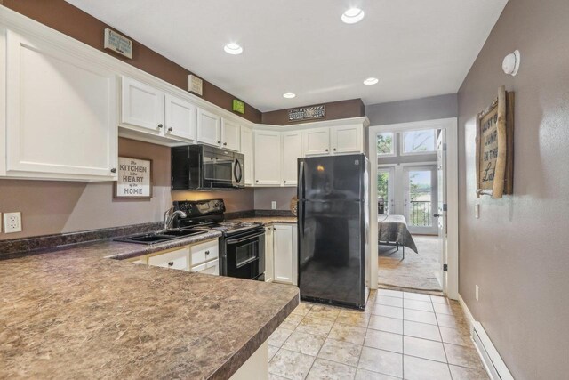 kitchen with black appliances, white cabinetry, a sink, and light tile patterned flooring