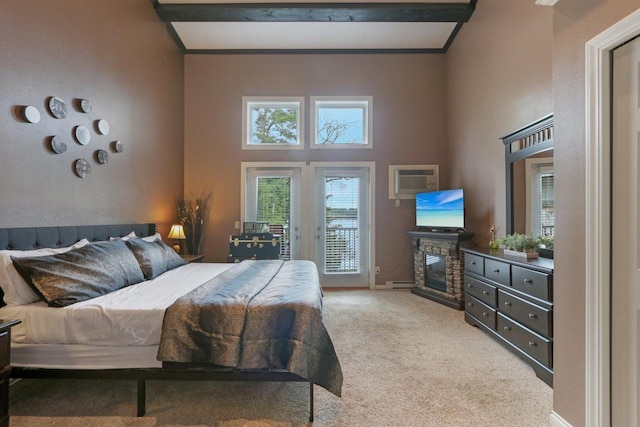 carpeted bedroom with a fireplace, baseboard heating, a high ceiling, access to outside, and baseboards