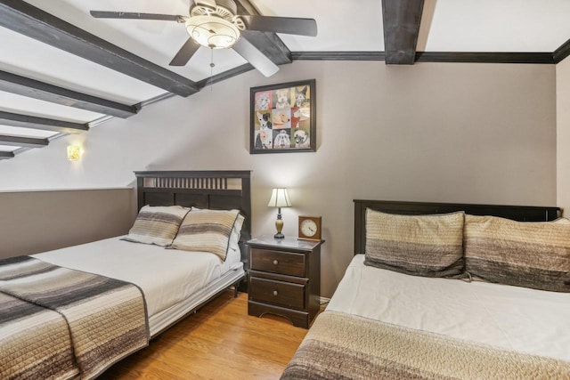 bedroom with ceiling fan, vaulted ceiling with beams, and light hardwood / wood-style floors