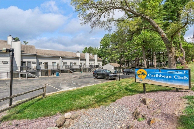 view of property's community featuring uncovered parking and fence