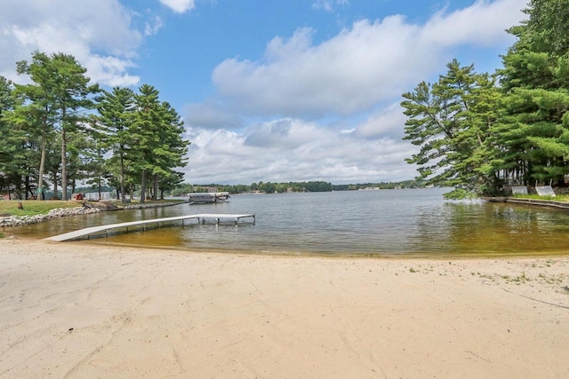 view of dock featuring a water view and a view of the beach