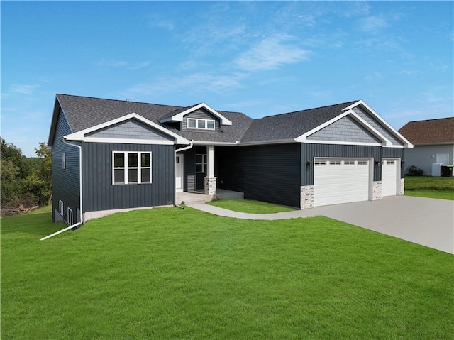 craftsman-style house with a front yard, a garage, and central AC unit