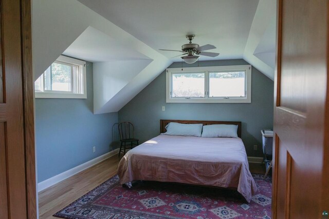 bedroom featuring ceiling fan, light hardwood / wood-style flooring, and lofted ceiling