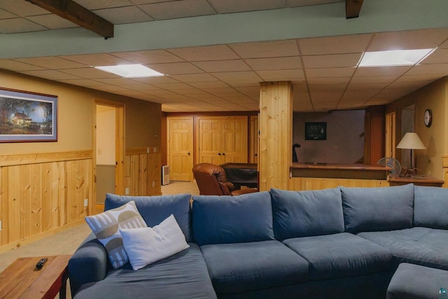 living room featuring beamed ceiling, a paneled ceiling, and carpet flooring