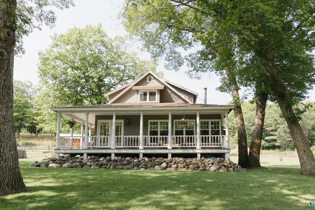 back of house featuring covered porch and a lawn