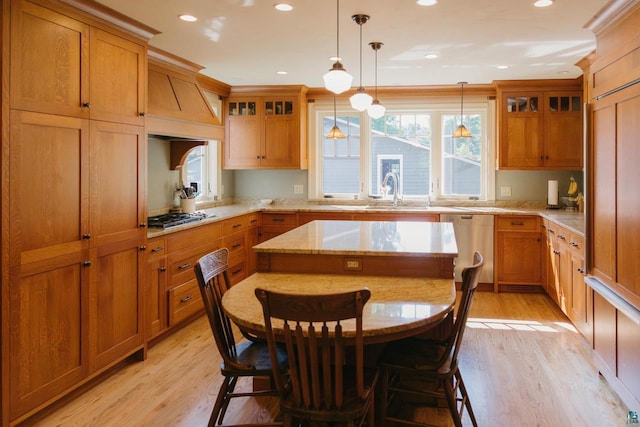 kitchen with custom exhaust hood, light wood-type flooring, a breakfast bar area, and pendant lighting