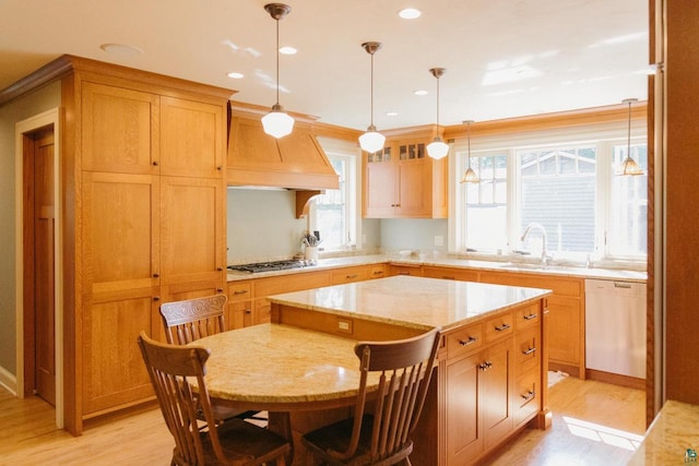 kitchen featuring custom range hood, light hardwood / wood-style flooring, decorative light fixtures, white dishwasher, and a center island