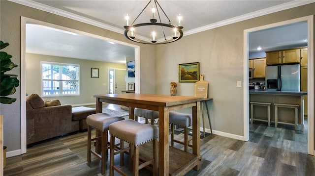 dining space with dark hardwood / wood-style flooring, a chandelier, and ornamental molding