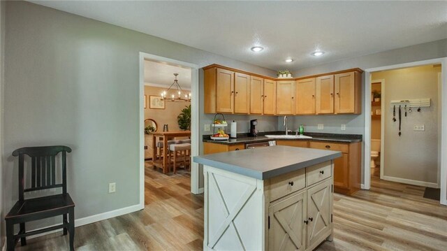 kitchen with a center island, sink, a chandelier, light hardwood / wood-style floors, and light brown cabinets