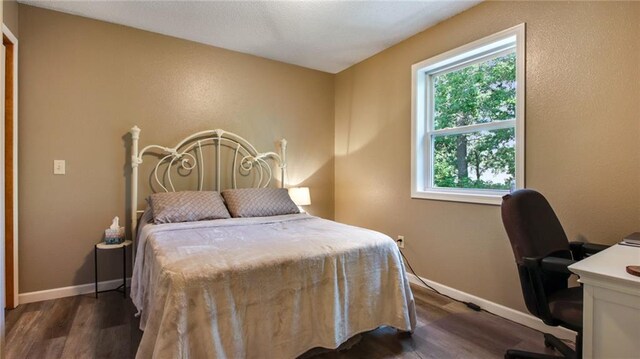 bedroom featuring dark wood-type flooring and baseboards