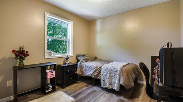 bedroom with light wood finished floors and baseboards