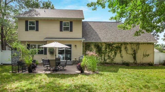 rear view of house featuring a patio and a yard