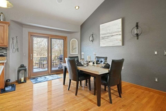 dining space featuring light hardwood / wood-style floors and lofted ceiling