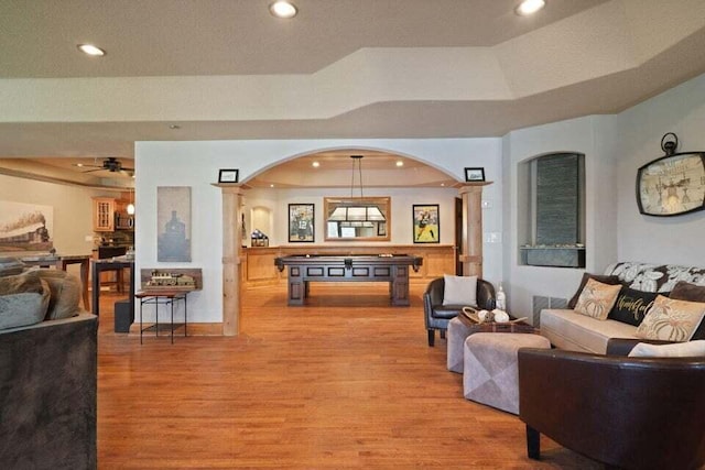 living room with ceiling fan, hardwood / wood-style flooring, pool table, and a tray ceiling