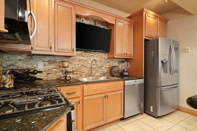 kitchen with decorative backsplash, appliances with stainless steel finishes, light tile patterned floors, sink, and dark stone countertops