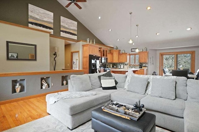 living room featuring high vaulted ceiling, ceiling fan, and light wood-type flooring