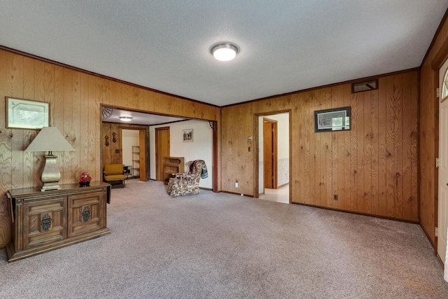 unfurnished room featuring baseboards, carpet, crown molding, and a textured ceiling