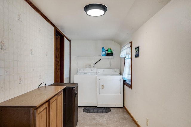 clothes washing area featuring cabinet space, baseboards, and washer and clothes dryer