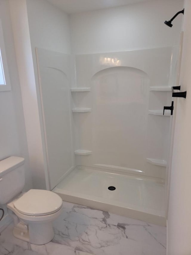 bathroom with marble finish floor, a shower stall, and toilet