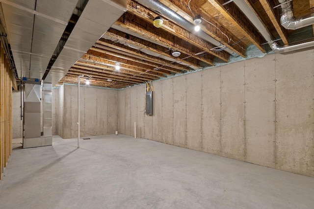 unfinished basement with electric panel and heating unit