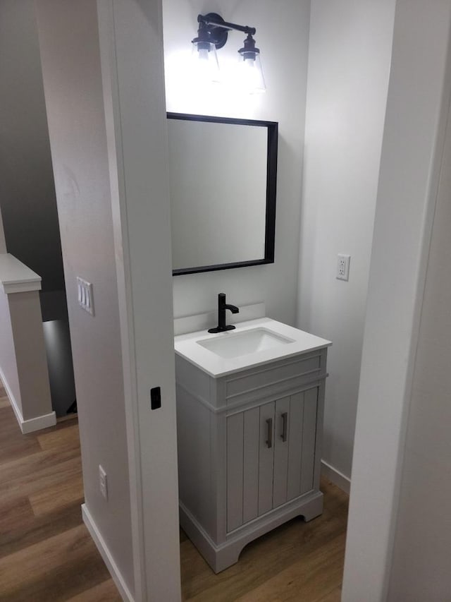 bathroom with vanity, baseboards, and wood finished floors