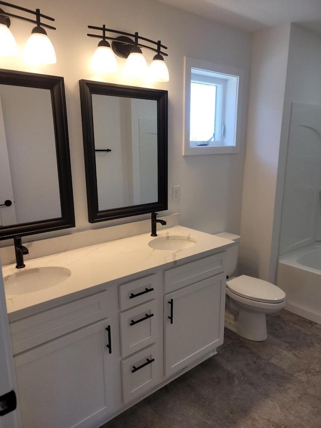 full bath featuring double vanity, toilet, and a sink