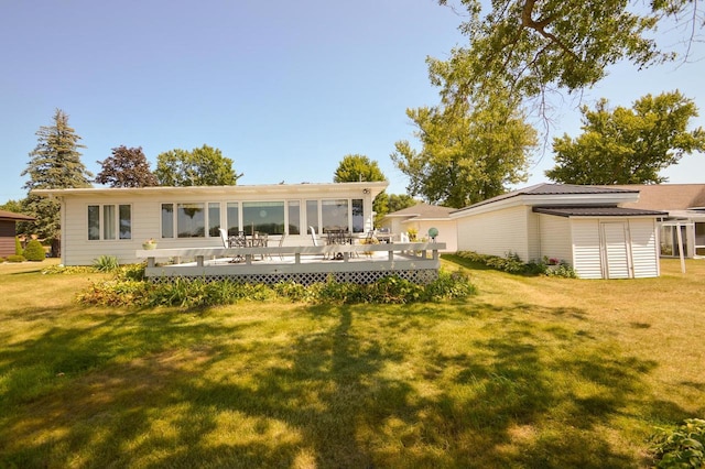 rear view of house featuring a lawn and a deck