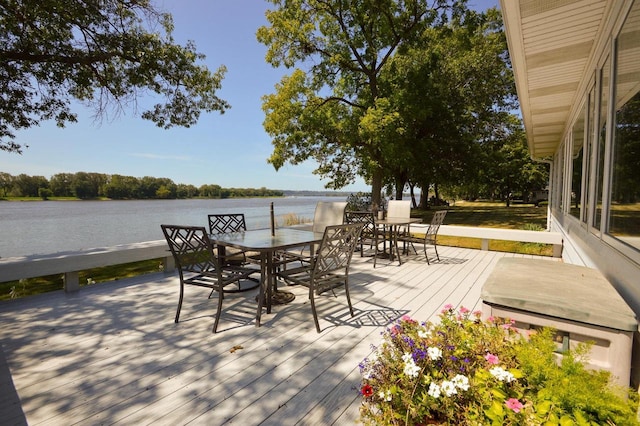 deck featuring outdoor dining area and a water view