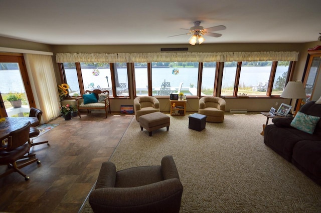 living room featuring plenty of natural light, a water view, visible vents, and a ceiling fan